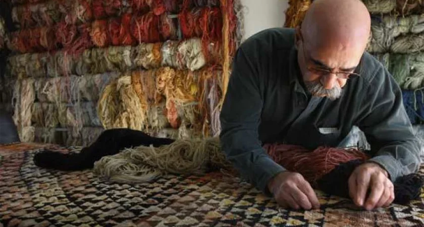 Hratch Kozibeyokian restoring a hand-woven carpet in his studio